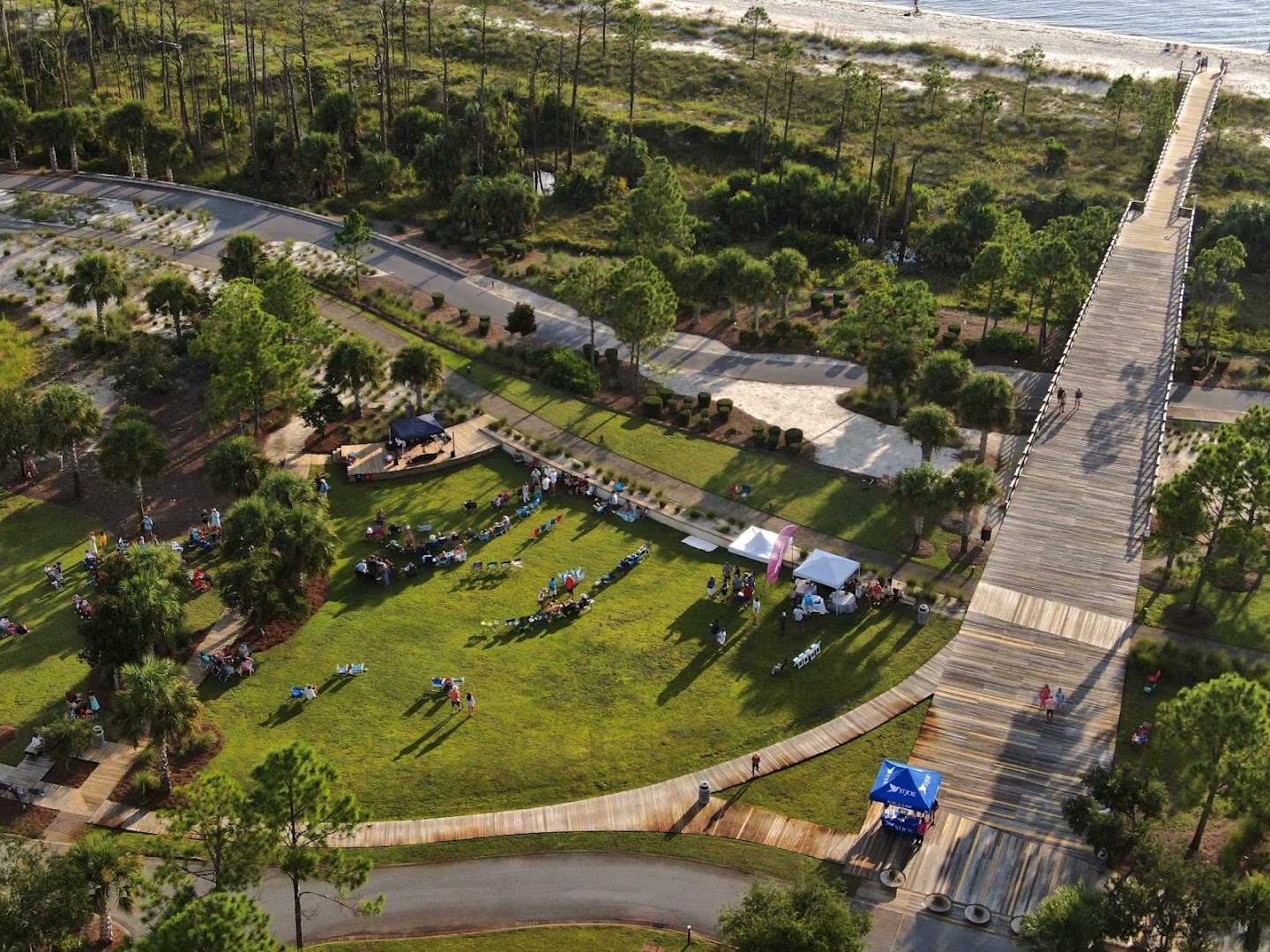 Aerial view of an outdoor special event beside a coastal boardwalk